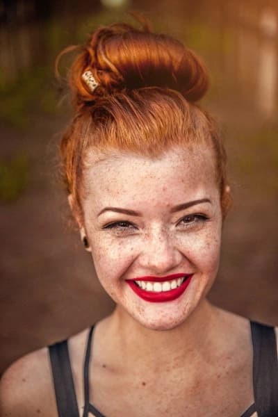 Portrait of a joyful woman with red hair and freckles, symbolizing ageless societies.